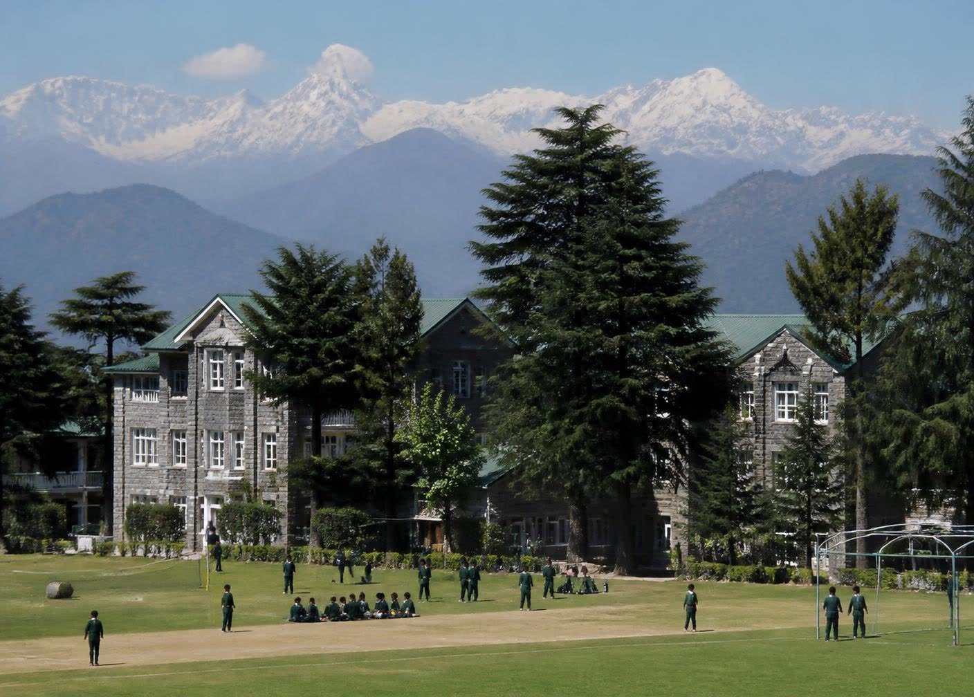 Hill-town school campus in Dharamshala with the Himalayan range behind